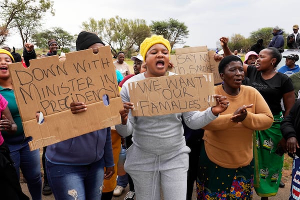 Relatives and friends protest near a reformed gold mineshaft where illegal miners are trapped in Stilfontein, South Africa, Friday, Nov. 15, 2024. (AP Photo/Denis Farrell)