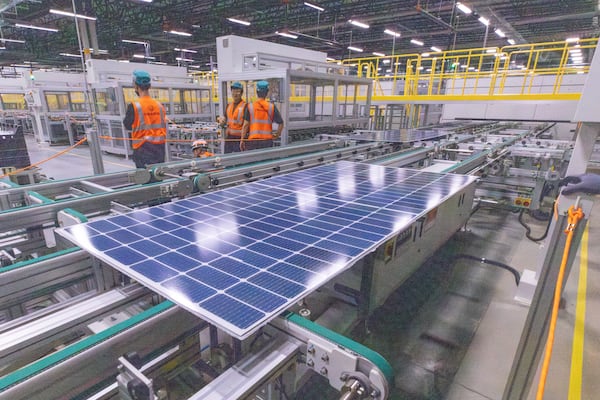 Workers keep an eye on the solar panels as they move through the automated assembly line at the Qcells module production facility in Cartersville on Tuesday, April 2, 2024.  (Steve Schaefer/steve.schaefer@ajc.com)