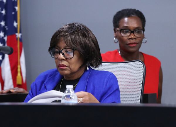 Councilwoman Hattie Portis-Jones (left) works at her seat as Mayor Elizabeth Carr-Hurst (right) arrives for the City Council work session and council meeting on Monday, August 12, 2019, in Fairburn. In an ethics complaint, Portis-Jones accused the mayor of fostering a “political environment of incivility, threats, attempted bodily harm and execution of bodily harm.” CURTIS COMPTON/CCOMPTON@AJC.COM