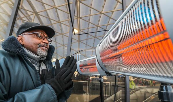 Skycap Tyrone Martin keeps warm Wednesday at Hartsfield-Jackson International Airport.