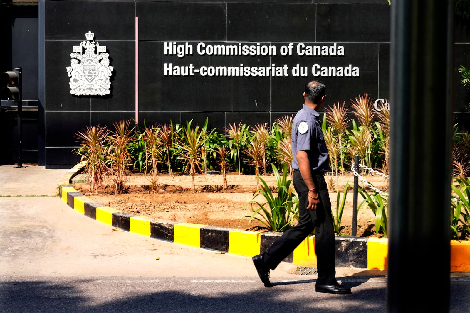 A private security man walks outside the Canadian high commission in New Delhi, India, Tuesday, Oct. 15, 2024 after India and Canada expelled each other’s top diplomats over an ongoing dispute about the killing of a Sikh activist in Canada. (AP Photo/Manish Swarup)