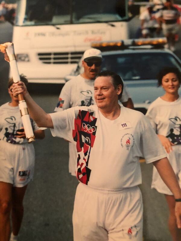 In the run-up to the 1996 Olympic Games, Dick Yarbrough, an Atlanta Olympic official, got to carry the torch near Atlanta. (Courtesy of Dick Yarbrough)