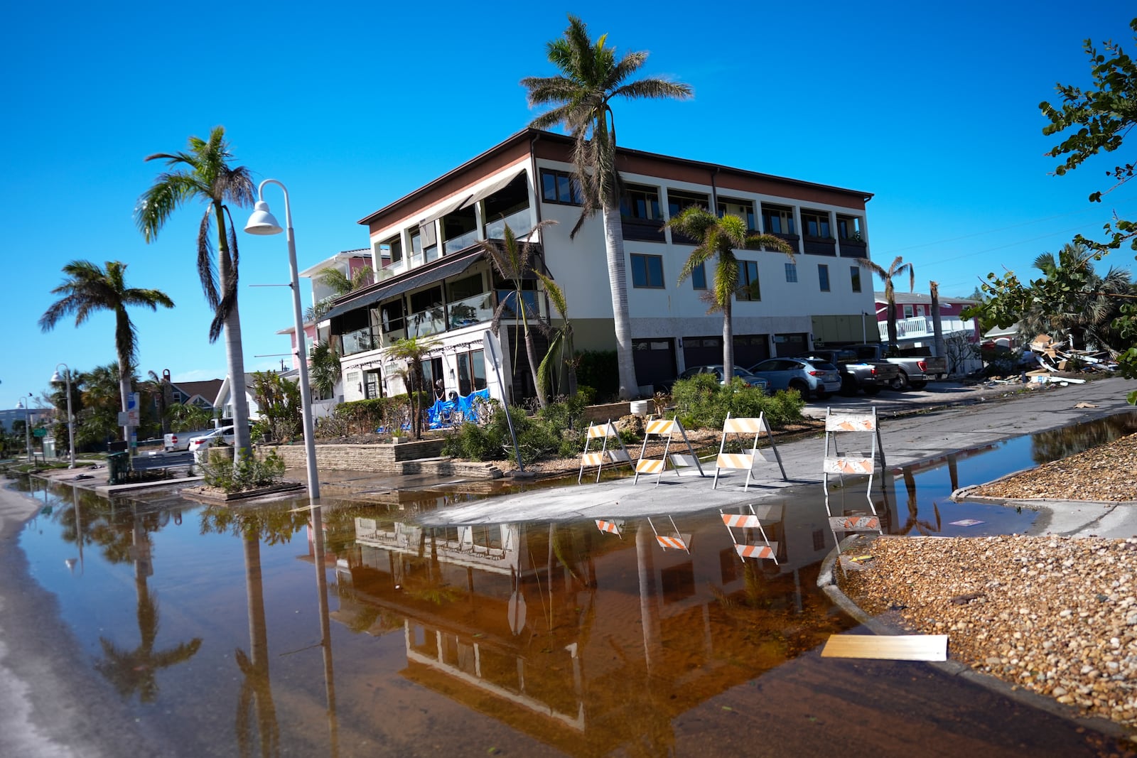 Rain flood waters recede around the bay-front home which Christian Burke's father had built to be hurricane proof and where Burke rode out Hurricane Milton along with his wife and aunt, in Gulfport, Fla., Thursday, Oct. 10, 2024. Even without the feared storm surge, Burke said the experience was intense and he won't feel the need to do it again. (AP Photo/Rebecca Blackwell)