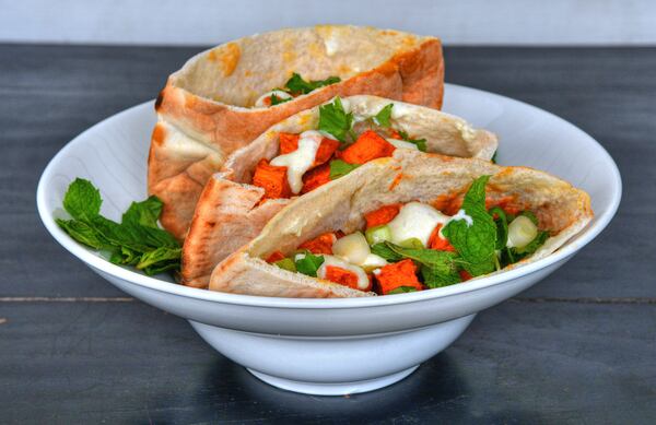 Roasted Sweet Potato Pockets With Whipped Feta Dressing, based on a recipe from Yalla executive chef Todd Ginsberg. (Styling by Lisa Hanson / Chris Hunt for the AJC)