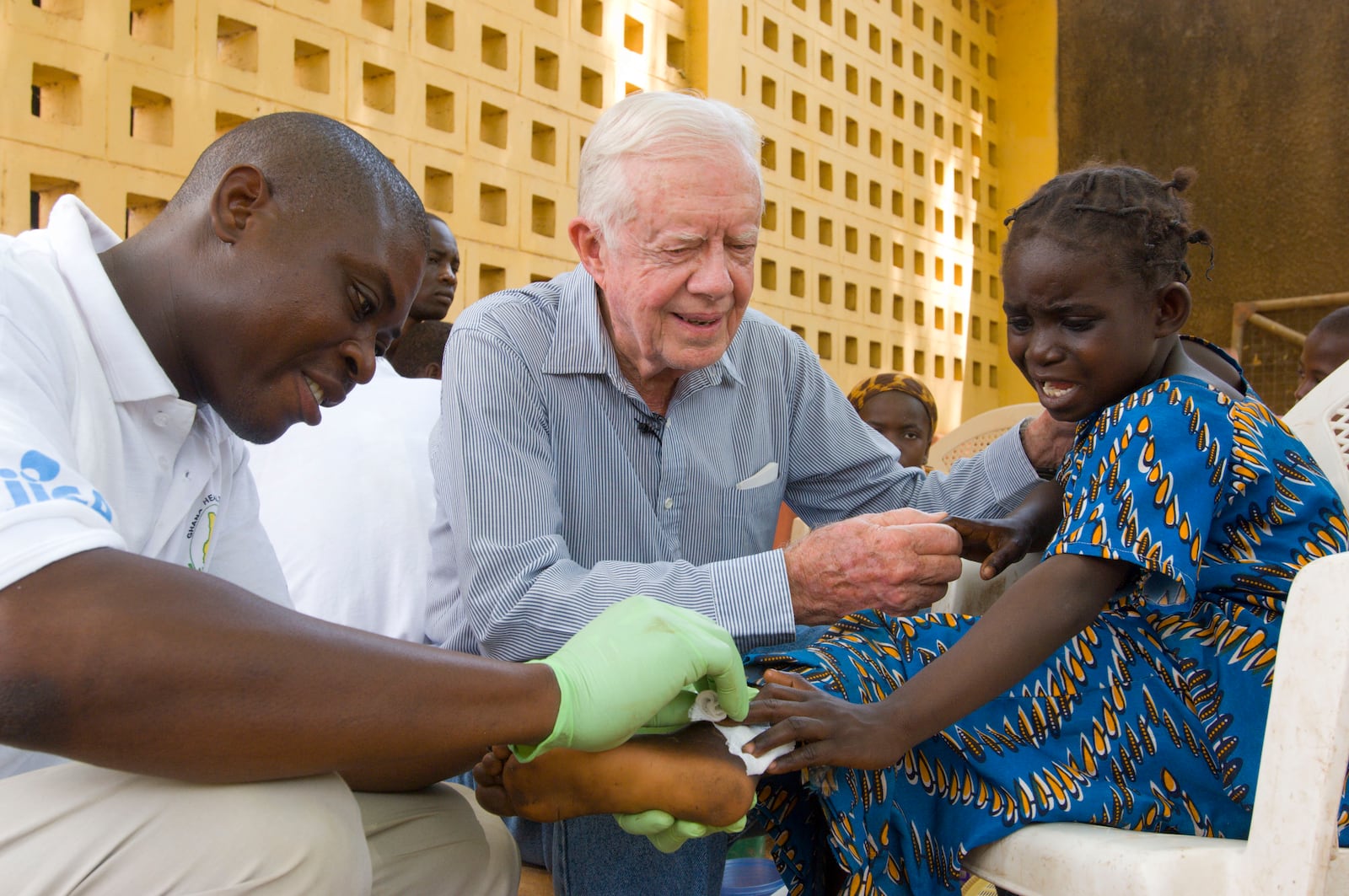 In this 2007 file photo, Jimmy Carter consoles a young patient having a Guinea worm removed from her body in Savelugu, Ghana. The Carter Center lead the international campaign to eradicate Guinea worm disease. (The Carter Center)