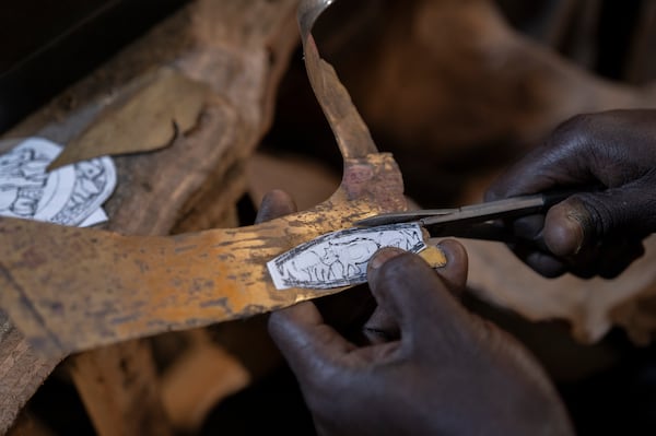 Jeweller Moussa Diop works on a bronze hippopotamus in his workshop, as part of the rebondir exhibition at the Dakar 2024 biennial Off in Dakar, Senegal, Thursday, Nov. 28, 2024. (AP Photo/Sylvain Cherkaoui)