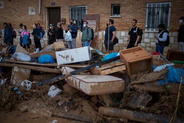 Residents wait for public transportation in an area, affected by floods, in Paiporta, Valencia, Spain, Tuesday, Nov. 5, 2024. (AP Photo/Emilio Morenatti)