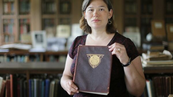 Associate Professor of History at Wesleyan College, Karen Huber, holds a 1913 edition of the college’s yearbook titled “Ku Klux”. 