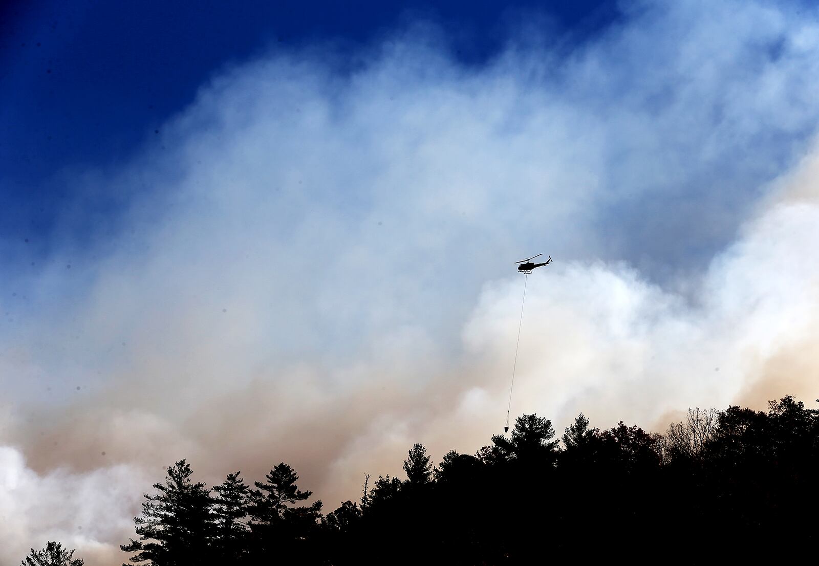 November 16, 2016, Tate City: A wall of smoke fills the air while a helicopter drops water on Pot Gap Ridge battling against the Rock Mountain Fire as it approaches homes on Wednesday, Nov. 16, 2016, in Tate City. Curtis Compton/ccompton@ajc.com