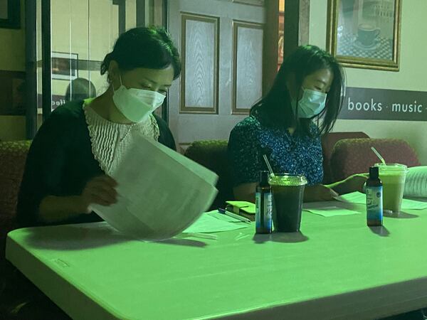 Bona Kim, (right) a licensed master social worker, goes through an informational packet on mental health during a seminar hosted in June by the Asian American Resource Center. 
 goes PARADISE AFSHAR/AJC