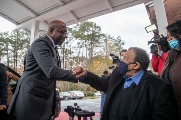 Democratic U.S. Senate candidate Rev. Raphael Warnock greets former Mayor of Atlanta and United Nations Ambassador Andrew Young (right) during early voting at the C.T. Martin Natatorium and Recreation Center near the Westhaven neighborhood in Atlanta on December 14, 2020.  (Alyssa Pointer / Alyssa.Pointer@ajc.com)