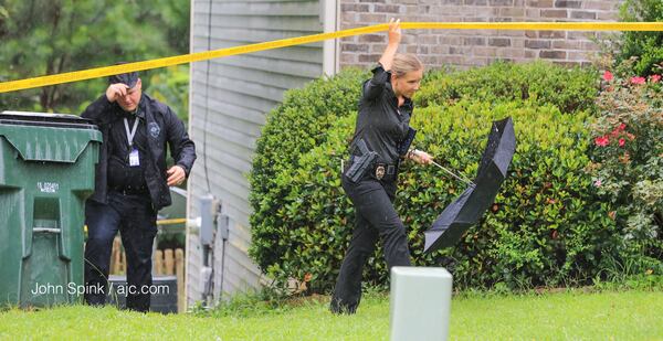 Investigators work the scene of a fatal shooting under rainy skies at a home on Grand Manor Trail near Snellville. JOHN SPINK / JSPINK@AJC.COM