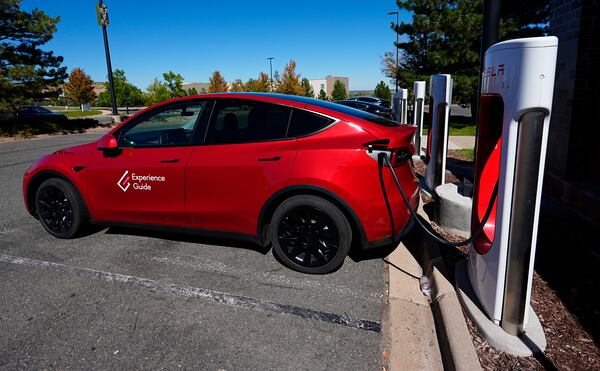 A Tesla Model 3 charges at a Tesla supercharging station situated in the parking lot of an outlet mall on Sept. 25 in Lakewood, Colo. (AP Photo/David Zalubowski, File)