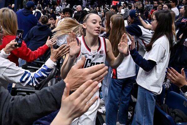 UConn guard Paige Bueckers slaps hands with the fans and the student section after an NCAA basketball game against Marquette, Sunday, March 2, 2025, in Storrs, Conn. (AP Photo/Jessica Hill)