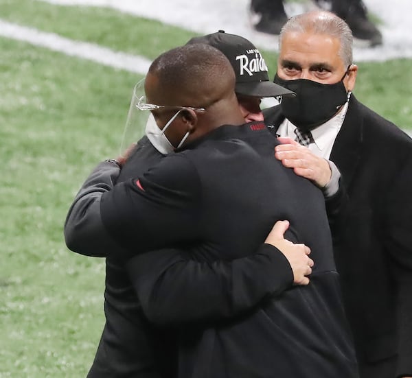 Atlanta Falcons head coach Raheem Morris and Las Vegas Raiders head coach Jon Gruden greet each other with a hug after the Falcons beat the Raiders 43-6 on Sunday, Nov. 29, 2020, in Atlanta, Georgia. (Curtis Compton/Atlanta Journal-Constitution/TNS)