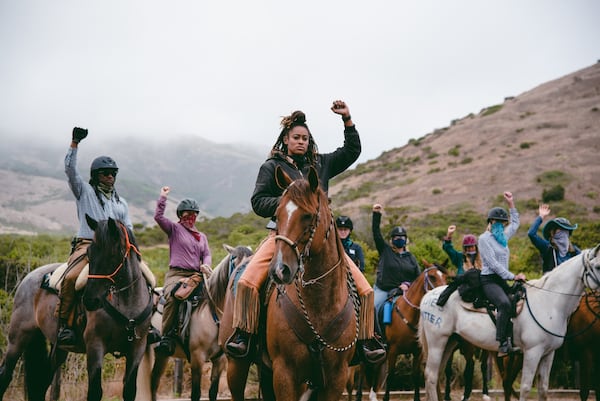 SAUSALITO, CA - JULY 26, 2020:  Brianna Noble leads a moment of silence with raised fists during the Heels Down Fists Up equestrian protest in solidarity with the Black Lives Matter movement on July 26, 2020 in Sausalito, Calif. CREDIT: Marissa Leshnov for SFGATE