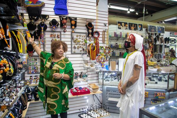 Afro-Centric Network employee Lula Williams, left, helps customer Amira Shade find jewelry during a visit to the store in Atlanta’s West End community, Wednesday, August 25, 2021. (Alyssa Pointer/Atlanta Journal Constitution)