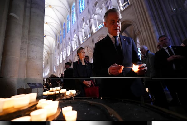 Canada's Prime Minister Mark Carney lights a candle while touring Notre-Dame Cathedral in Paris, Monday, March 17, 2025. (Sean Kilpatrick/The Canadian Press via AP)