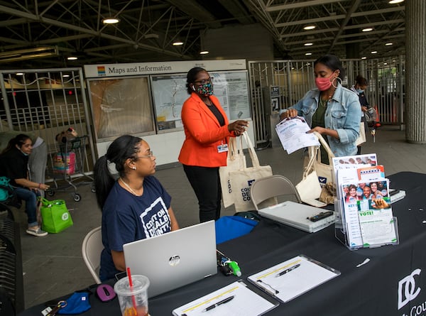 DeKalb County Election officials including Nytia Harris, front left, Erin Adam and Lamashia Davis work to spread information about changes in voter laws and offer free voter IDs, if needed, on Wednesday, Sept 15, 2021 at the Chamblee MARTA Station.  (Jenni Girtman for The Atlanta Journal-Constitution)