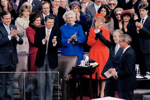 Outgoing President Jimmy Carter waves to the crowd at the inauguration of 40th President Ronald Reagan in Washington, D.C., on Jan. 20, 1981. In the background, new Vice President George Bush, Reagan, Barbara Bush and first lady Nancy Reagan applaud. Next to Carter is outgoing Vice President Walter Mondale, and at far right, Reagan's son Ron applauds. AP 1981