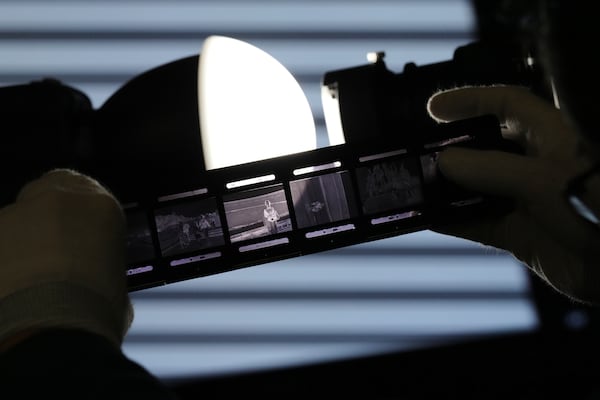 Shinji Teruya prepares to scan an old negative of his father-in-law, Katsumoto Saotome, at the Center of the Tokyo Raids and War Damage on Feb. 4, 2025, in Tokyo. (AP Photo/Eugene Hoshiko)