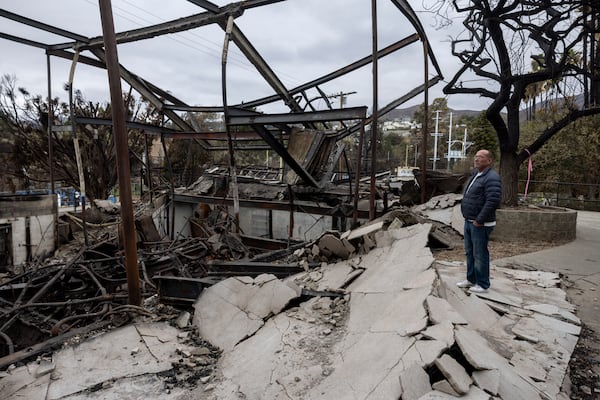 Costume designer for the youth theatre program of the Theatre Palisades, David Montgomery looks at the ruins of the theater destroyed by the Palisades Fire, in the Pacific Palisades neighborhood of Los Angeles, Calif., Saturday, Jan. 25, 2025.(AP Photo/Etienne Laurent)