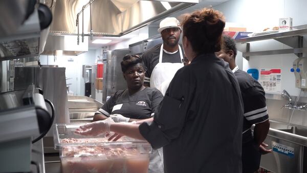 Antonia Thomas, left, gets ready to prep chicken at the West Nest restaurant inside the new Falcons stadium. Thomas is one of hundreds of residents who have benefited from job training programs provided by Westside Works. Contributed