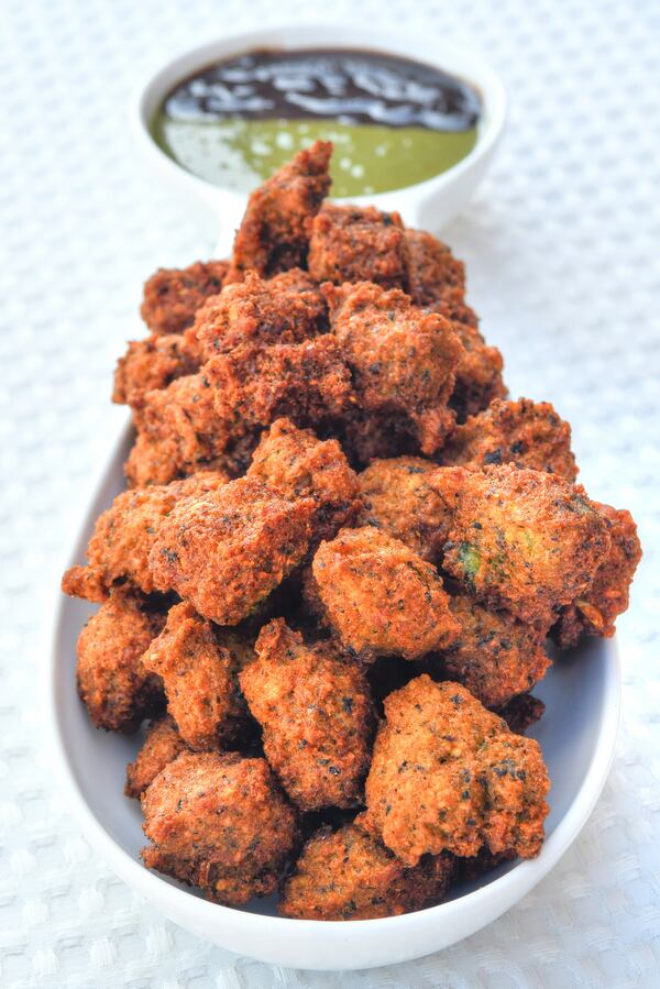 Black-Eyed Pea Vada (Fritters). On a trip to India in 2016, Farhan Momin encountered a vendor frying fritters (vada) made of ground mung beans, a traditional Gujarati street snack. He came up with the genius idea of replacing the mung beans with black-eyed peas, a staple in the cuisines of India and the American South. The fritters are excellent with a drizzle of the Momin family's green and tamarind chutneys (in background; recipes included). (Styling by chef Farhan Momin / Chris Hunt for the AJC)