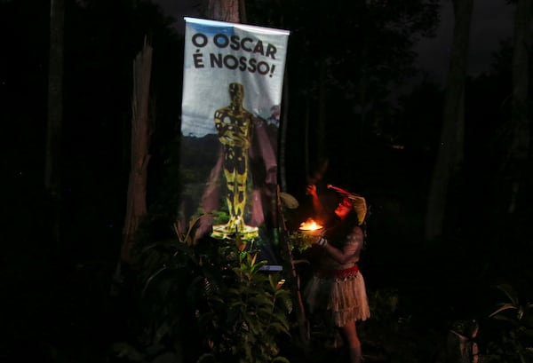 A woman from the Indigenous ethnic group Kokama performs a ritual to send good energies for the film "I'm Still Here," which has been nominated for several Oscars including, best film, best international feature and best actress, at the Inhaa-be village, Manaus, Amazonas state, Friday, Feb. 28, 2025. (AP Photo/Edmar Barros)