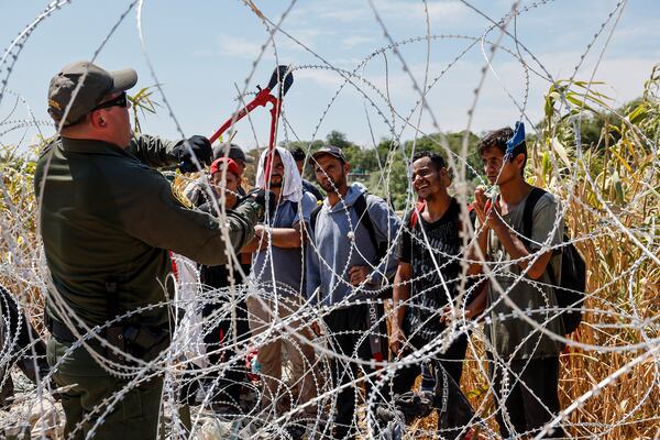 A border patrol agent cuts razor wire near the Camino Real International Bridge connecting the U.S. and Mexico border cities.(Robert Gauthier/Los Angeles Times/TNS)