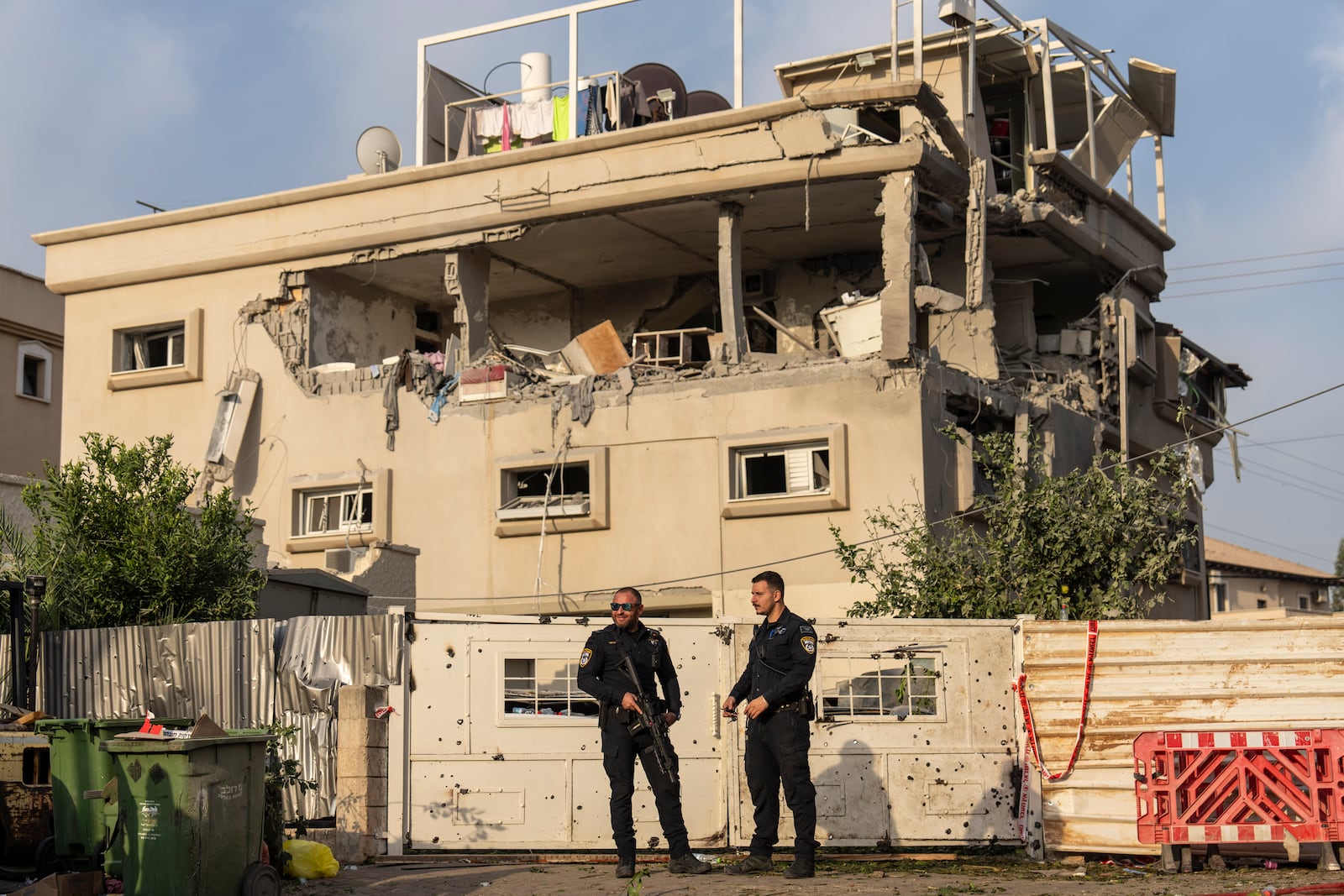 Israeli police men work at the site where projectiles fired from Lebanon hit a home in Tira, central Israel, Saturday, Nov. 2, 2024. (AP Photo/Ariel Schalit)