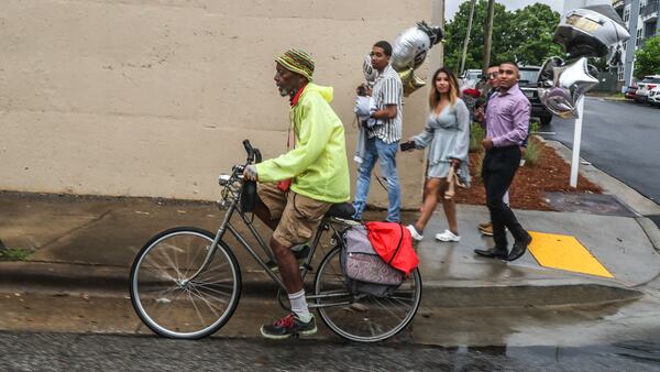 Al Blair makes his way down Fulton Street in Atlanta with his rain coat as rain threatens Friday morning. The risk of severe weather goes up at midday.