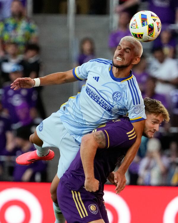 Atlanta United's Luis Abram, ltop, jumps over Orlando City's Duncan McGuire, bottom to control a head ball during the second half of an MLS Semifinal Conference playoff soccer match, Sunday, Nov. 24, 2024, in Orlando, Fla. (AP Photo/John Raoux)