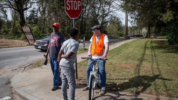 Bob Gilman (R) talks with his neighbors at the intersection of Bouldercrest Road and Cecilia Drive Southeast where a mother discovered her 3-year-old boy had been killed in a drive-by shooting Sunday night. STEVE SCHAEFER / SPECIAL TO THE AJC