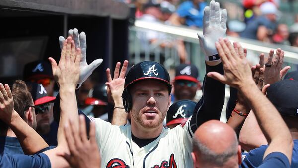 Braves' Freddie Freeman gets high-fives in the dugout hitting a 2-RBI home run Sunday, April 28, 2019, against the Colorado Rockies Sunday, April 28, 2019, at SunTrust Park in Atlanta.