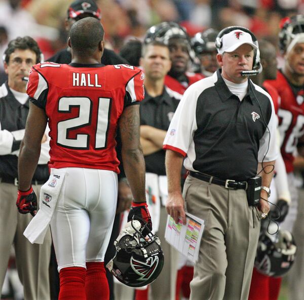 Falcons cornerback DeAngelo Hall walks past coach Bobby Petrino.      CURTIS COMPTON / Staff