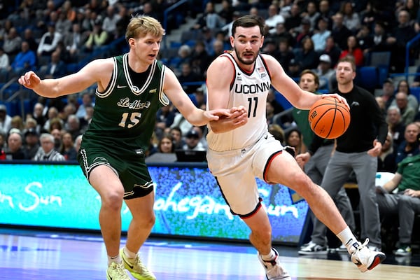 UConn forward Alex Karaban (11) drives to the basket as Le Moyne forward Nate Fouts (15) defends in the first half of an NCAA college basketball game, Wednesday, Nov. 13, 2024, in Hartford, Conn. (AP Photo/Jessica Hill)