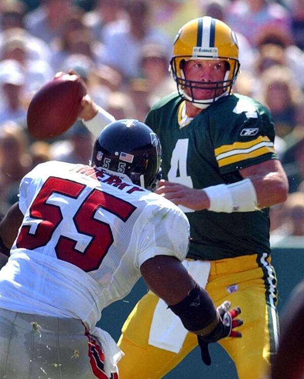  020908 GREEN BAY:--RUNNING AWAY FROM THE DEFENSE--Packers quarterback Brett Favre looks to pass under pressure from Falcons linebacker John Thierry during 1st half action at Lambeau Field on Sunday, Sept. 8, 2002. (CURTIS COMPTON/staff)