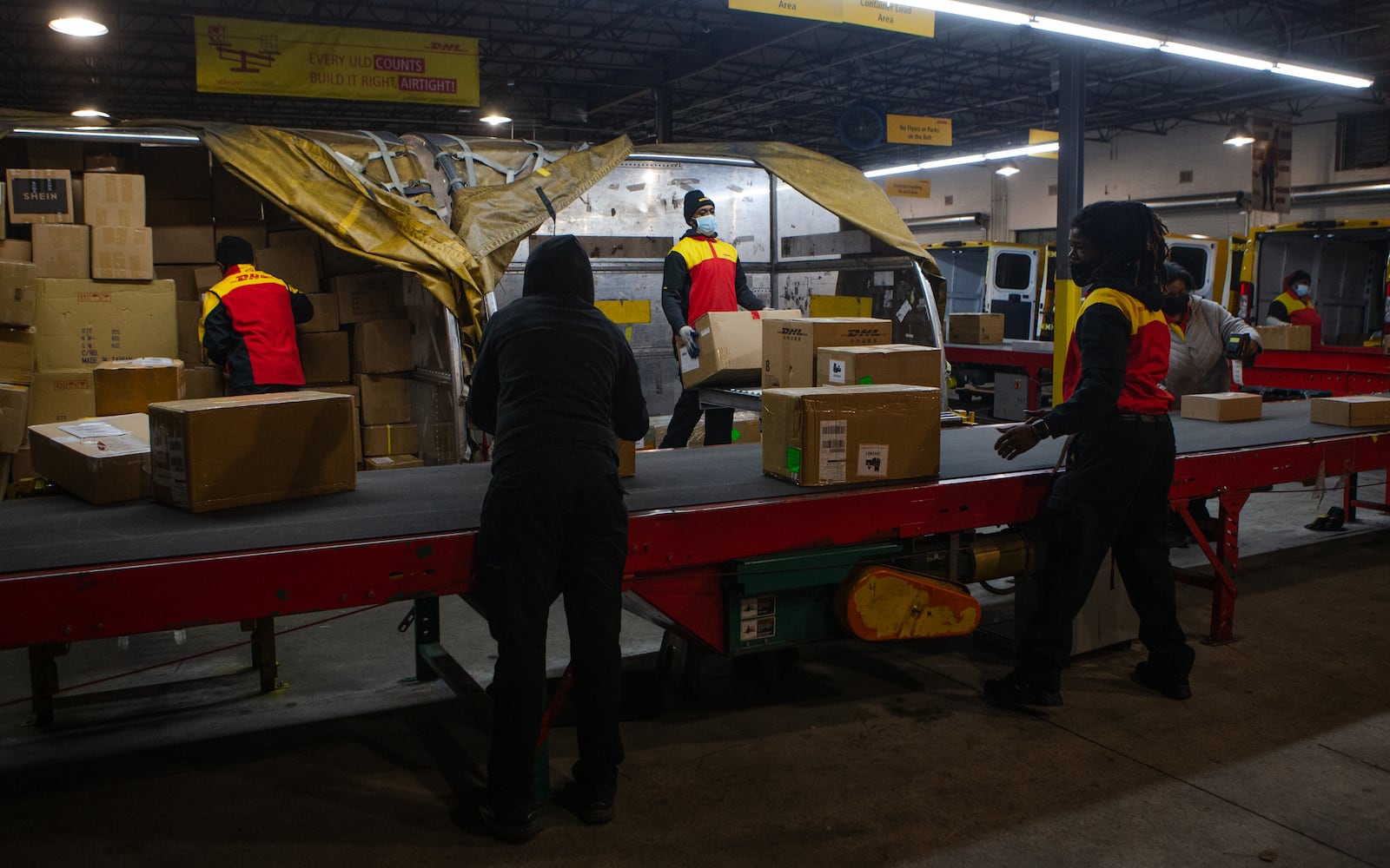 DHL employees sort packages on Wednesday, December 16, 2020, at DHL Express in Atlanta. Workers at the shipping center worked to fulfill orders during the holiday rush. CHRISTINA MATACOTTA FOR THE ATLANTA JOURNAL-CONSTITUTION.