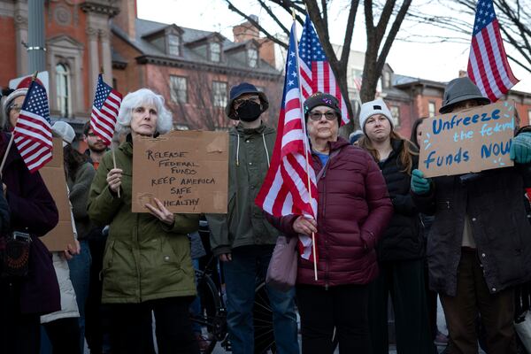 People protest against a funding freeze of federal grants and loans following a push from President Donald Trump to pause federal funding near to the White House in Washington, Tuesday, Jan. 28, 2025. (AP Photo/Ben Curtis)