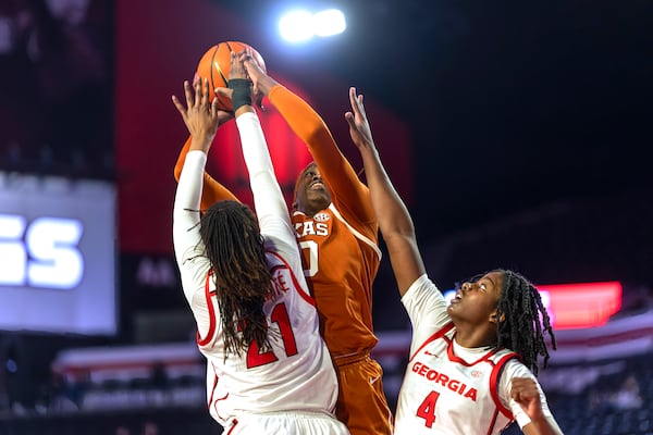 Texas forward Kyla Oldacre), center, attempts to make a basket against Georgia forwards Fatima Diakhate, left, and Miyah Verse (4) during the first half of an NCAA college basketball game, Monday, Feb. 24, 2025, in Athens, Ga. (AP Photo/Erik Rank)