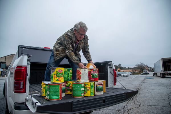 Bob Wertz, a member of the Fayette Samaritans, donates food at the drive-through food pantry at the Hearts to Nourish Hope in Riverdale last month. Federal rescue packages helped millions across the country, but back rent and late mortgage payments continue to build, and ultimately will have to be repaid, forgiven or settled in bankruptcy court. (Alyssa Pointer / Alyssa.Pointer@ajc.com)