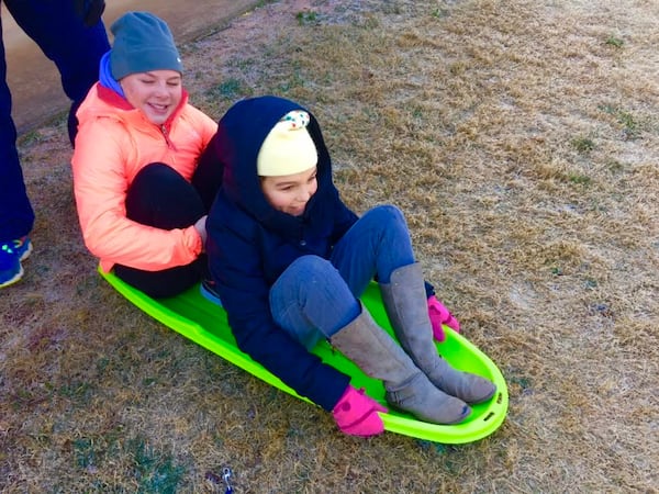 Isabel (reporter's daughter), who is 9 and her friend Lily Newman, 10, make the most out of dusting of snow.