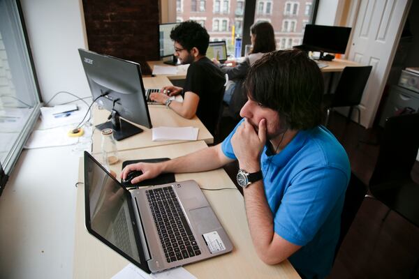 Draftpot co-founder and CEO Joey Levy, foreground, works with co-founder and CTO Joshua Hughes, center, and co-founder and developer Jessica Vandebon at the Fantasy Football operation's workspace, Wednesday, Sept. 30, 2015, in New York. After starting up from their dorm rooms at Columbia University earlier this year, the operation paid out $220,000 in it's first week online. (AP Photo/Julie Jacobson)