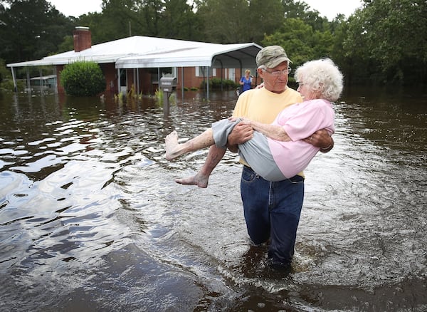 SPRING LAKE, NC - SEPTEMBER 17: Bob Richling carries Iris Darden as water from the Little River starts to seep into her home on September 17, 2018 in Spring Lake, North Carolina. Flood waters from the cresting rivers inundated the area after the passing of Hurricane Florence. (Photo by Joe Raedle/Getty Images) *** BESTPIX ***