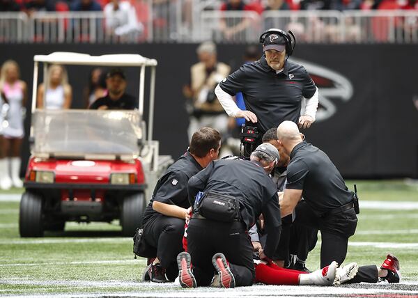 Falcons head coach Dan Quinn watches as medical personnel evaluate injured running back Ito Smith during the first half Sunday, Oct. 20, 2019, at Mercedes-Benz Stadium in Atlanta.