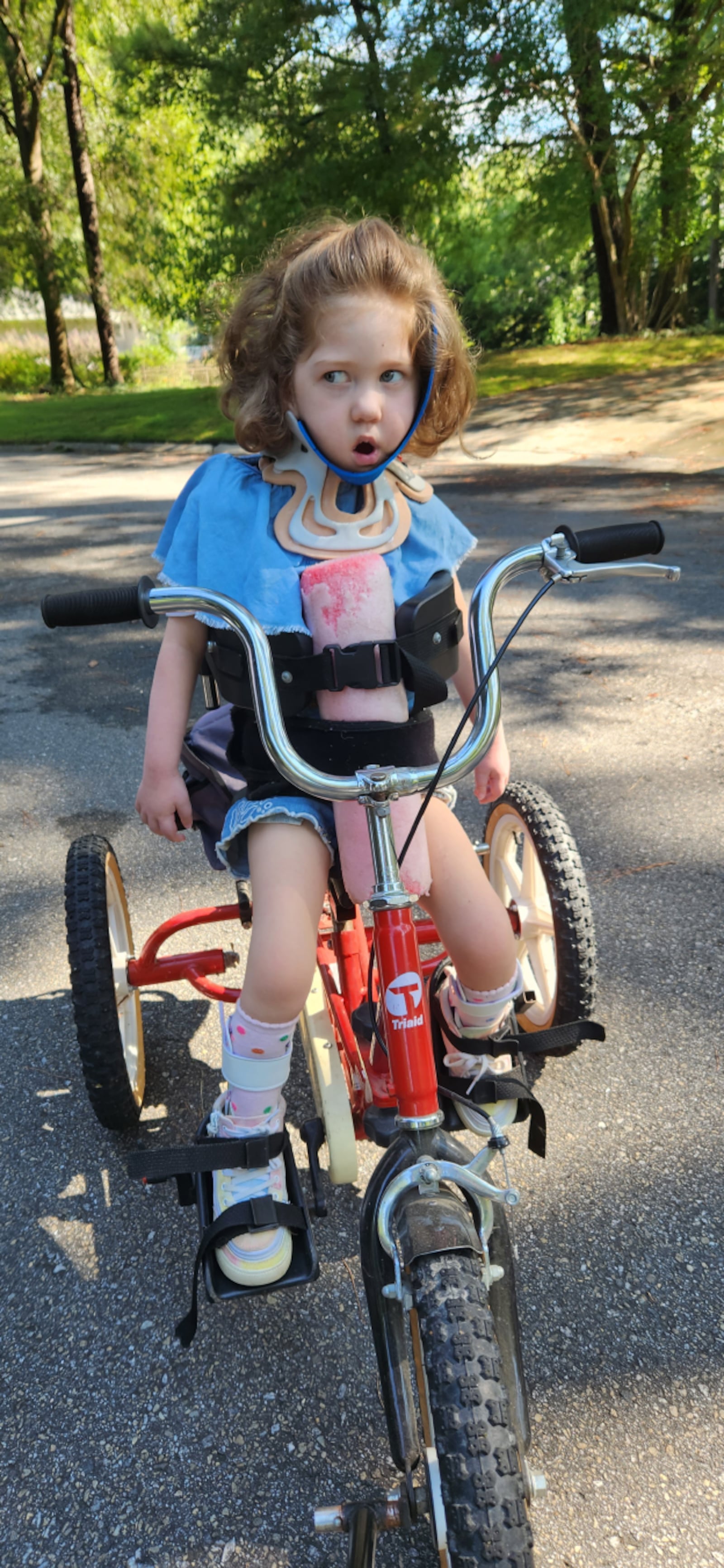 Engaging with others has been extra difficult for Catherine since she is unable to hold her head up on her own. Someone props her just right if she is sitting and, when she rides her adapted bicycle, it takes two hands to assist her, one to push the bike and another to hold her head. (Courtesy of Mary Reed)