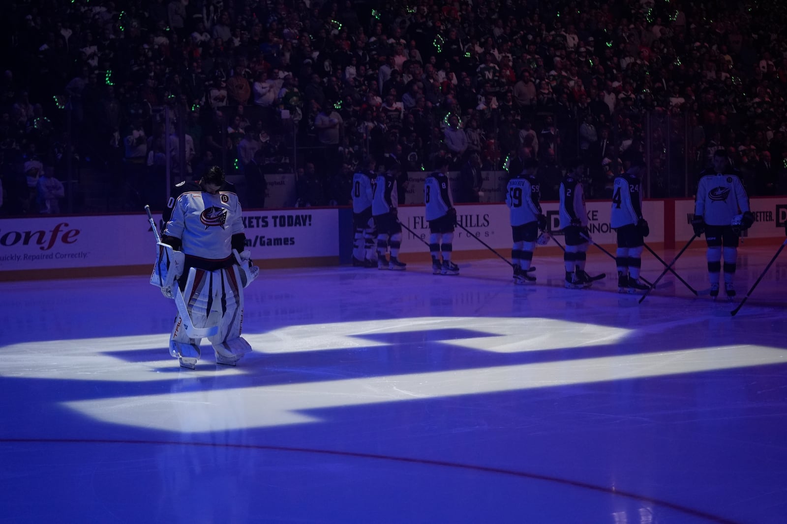 Columbus Blue Jackets goaltender Elvis Merzlikins (90) stands on a No. 13 on the ice honoring former Blue Jackets player Johnny Gaudreau and his brother Matthew Gaudreau who were killed by a driver in New Jersey in August, before an NHL hockey game against the Minnesota Wild, Thursday, Oct. 10, 2024, in St. Paul, Minn. (AP Photo/Abbie Parr)