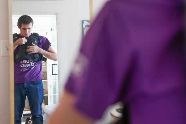 Tom Kerekes shows a vibrating vest he previously relied on to loosen mucus in his lungs. He says that since he's been on the new drug treatment, his lungs have been functioning much better and he no longer uses the vest. (Natrice Miller/natrice.miller@ajc.com)  