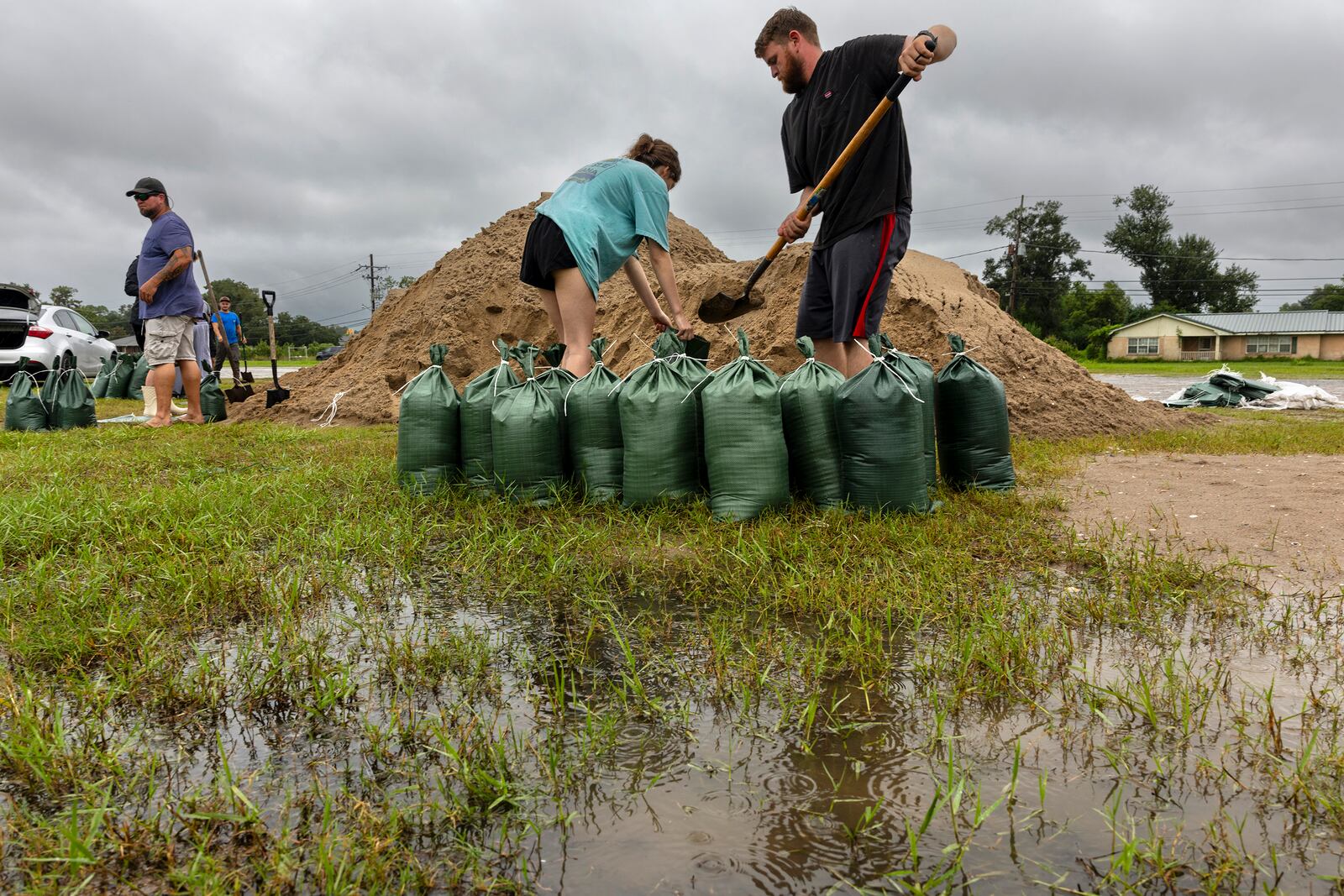 Rainwater accumulates around Nolan and Macie Melancon as they fill up sandbags for their home located a few miles away in Houma, La., as the region gets ready for the arrival of Hurricane Francine on Tuesday, Sept. 10, 2024. (Chris Granger /The Times-Picayune/The New Orleans Advocate via AP)